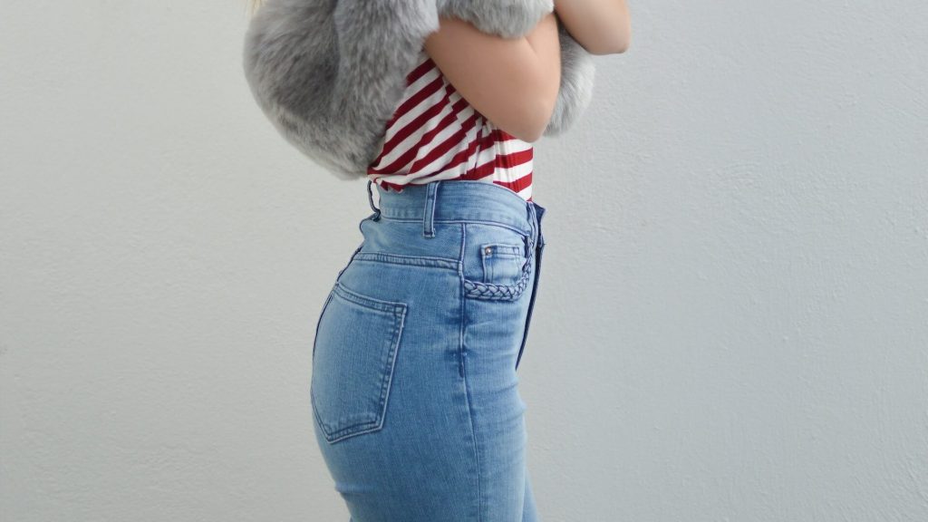 A woman dressed in high-waisted jeans, showcasing a trendy and flattering fashion choice.